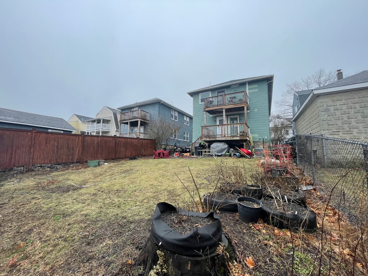 Uneven sloped yard before retaining wall